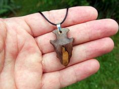 I hand-carved this one-of-a-kind arrowhead pendant from Spalted Walnut with very unique spalting lines. It's fully carved in the round on both sides so you can hang either way. I like the look of primitive arrowheads so I emulate that style in my carvings.  A hand rub finish is applied and then the pendant is buffed to a buttery smooth final finish that feels amazing to the touch.  You can choose from a variety of necklace/cording options including: 18" or 22" stainless steel chain A variety of Rustic Carved Jewelry As Gift, Artisan Arrowhead Necklace For Gift, Rustic Handmade Arrowhead Necklace, Rustic Arrowhead Necklace For Gift, Brown Arrowhead Necklace For Gift, Arrowhead Pendant, Natural Necklace, Minimalist Pendant, Arrowhead Necklace