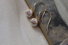 "Beautiful handmade Victorian inspired small dangle drop earrings featuring a charming Antique roses cabochons set in raw gold plated brass. Mounted on a gold plated fish hook ear wires. Measurements: approx. 1.25\" ✭ Shop more jewelry here ➜ https://www.etsy.com/shop/adriancompany?section_id=33299650 ✭ Adrian Company Vintage is partnering with The Veiled Ghost to offer handmade modern jewelry with Gothic Victorian Antique feel. ✭ All Veiled Ghost jewelry is nickel and lead free. ✭ All Veiled Gh Raw Gold, Gothic Victorian, Vintage Ribbon, Handmade Modern, Antique Roses, Silver Spring, White Gifts, Rose Earrings, Dream Jewelry