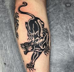 a black and white tattoo on the leg of a man with an animal design on it