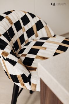 a black and white checkered chair sitting on top of a wooden table next to a counter