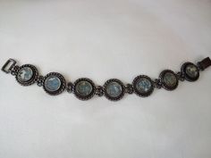 Stunning vintage bracelet by Modernist designer Luli Hammerztein. This artist uses only authentic artifacts in her creations. This bracelet features a stunning Modernist design, beautiful round links of sterling silver and blue with speckles Roman Glass.  Signed on back of each link. Measures 7.5 inches long approx, 3/4 inches wide. Beautiful condition, secure hook clasp. Truly a Beautiful creation! Round Spiritual Collectible Bracelets, Artisan Cabochon Bracelet Jewelry, Adjustable Antique Finish Jewelry Bracelet, Adjustable Antique Finish Bracelet, Antique Oxidized Bracelet, Handmade Adjustable Antique Bracelets, Antique Oxidized Finish Bracelets, Antique Bracelet With Oxidized Finish, Antique Round Bracelet With Oxidized Finish