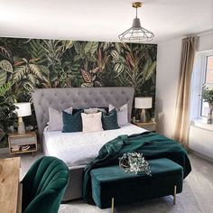 a bedroom decorated in green and white with a large bed, two chairs, and a footstool