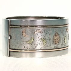 Whenever I talk about antique jewelry, I like to refer to it as 'wearable art', no where is this more clearly seen than with English Victorian silver jewelry. Each bangle, collar, earring, locket, was lovingly and elaborately made, with gold overlay, with fantastic engraving, with embossed designs, one piece more stunningly detailed than the next. This fabulous bangle was hand crafted in England around 1880. It has a lovely soft bloomed finish and is decorated with richly detailed engraving and Victorian Style White Gold Bracelets For Formal Occasions, Victorian White Gold Bracelets For Formal Occasions, Formal Cuff Bracelet With Intricate Design, Antique White Gold Bracelets For Anniversary, Heirloom Cuff Bracelet With Intricate Design For Formal Occasions, Antique Polished Bracelets For Formal Occasions, Antique Formal Bracelets With Box Clasp, Victorian Historical Jewelry For Formal Occasions, Victorian Style Jewelry With Historical Design For Formal Occasions