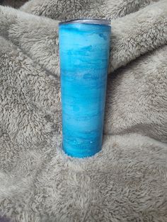 a blue cup sitting on top of a blanket