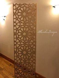 a tall metal screen sitting on top of a hard wood floor next to a wall