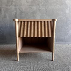 a small wooden table sitting on top of a carpeted floor next to a wall