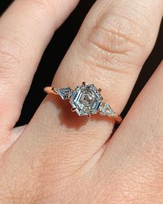 a woman's hand with a diamond ring on top of her finger and an engagement band