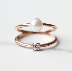 A unique solitaire engagement or birthstone diamond and pearl ring with a double band. Details Gemstone: white diamond Shape: round Measurements: approx. 3mm, 0.10ct Quality: G golour, VS clarity, conflict-free Gemstone: freshwater pearl Shape: round Measurements: approx. 5.5 - 6mm Band measurements: approx. 1.6 mm Material: 14k solid yellow gold, white gold, rose gold or 18k solid yellow gold, white gold, rose gold, (platinum for extra fee) Sizes available: 3-8 (Larger and smaller sizes are ava Diamond Solitaire Pearl Promise Ring, Rose Gold Double Band Stackable Rings For Wedding, Minimalist Diamond Pearl Promise Ring, Minimalist Open Pearl Ring With Diamonds, White Gold Pearl Ring With Diamond For Anniversary, Minimalist Diamond Pearl Ring For Formal Occasions, Anniversary White Gold Pearl Ring With Diamond, Fine Jewelry Pearl Ring With Diamonds In Rose Gold, White Gold Pearl Ring With Single Diamond For Promise