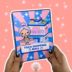 a person holding up a pink and blue sticker that says toca shopping mall