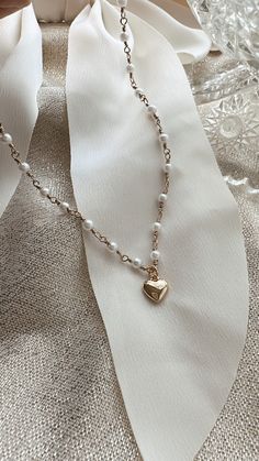 Dainty Gold Pearl Necklace with Gold Puffy Heart * Material: Stainless Steel/ Nickel Free * Dimensions: 16 inches long * Finish: 18K Gold Plated  * All our jewelry is curated with love and care with you in mind! ♥ * Ready to ship 1-3 business days. * IG: @sydneyashlynco -----------------------♥-------------------- * All images are copyrighted by Sydney Ashlyn & Co. All rights reserved * ~ Shipping Information ~ Please be sure to double check that your shipping address is updated. We will ship th White Clavicle Chain Necklace For Valentine's Day, Elegant White Heart Necklace With Chain, Heart-shaped Wedding Necklace With Chain Detail, Dainty Heart Necklace With Pearl Chain For Valentine's Day, Heart-shaped Chain Necklace For Wedding, Dainty Pearl Chain Necklace For Valentine's Day, Dainty Heart Necklace With Pearl Charm For Valentine's Day, Heart-shaped Pearl Chain Necklace For Valentine's Day, Heart-shaped White Chain Necklace For Gift