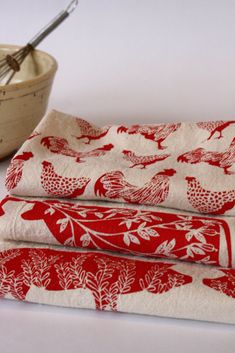 three red and white birds printed napkins next to a bowl with whisk