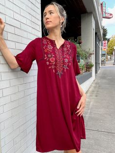 "Handcrafted in a sumptuous silky rayon, the Josefina dress features an easy slip on fit with princess seams in the bodice, ample width in the hip, petal bell sleeve, and rich hand embroidered details on the front and neck. Designed longer, by customer request, the center back length is 39\" for size S. Pre-washed, machine washable. Fair trade verified. Model is 5'9 size S. *Embroidery may vary slightly due to the handcrafted nature of the garment." Elegant Tunic Embroidered Dress With Floral Details, Elegant Floral Embroidered Tunic Dress, Rayon Boho Maxi Dress, Boho Rayon Maxi Dress, V-neck Embroidered Dress With Embroidered Neckline, Festive Short Sleeve Embroidered Dress, Bohemian Midi Dress With Floral Embroidery And Short Sleeves, Traditional Flowy Embroidered Dresses, Traditional Embroidered Flowy Dress