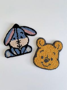 two winnie the pooh patches sitting next to each other