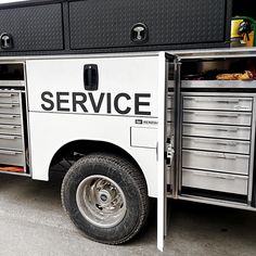 the service truck is parked on the side of the road with it's doors open