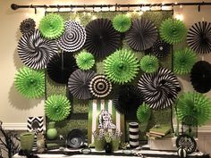 green and black decorations are on display in front of a wall with white and black decor