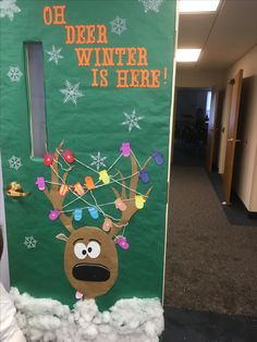 a door decorated to look like a reindeer with christmas lights on its antlers and the words, deer winter is here