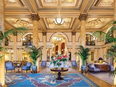 an ornate lobby with chandeliers and large rugs on the floor in front of it