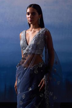 Grey saree crafted in net with Eden floris embroidery using silver leather applique and mirror encrusted with zari highlights. Paired with a sleeveless plunging V neck blouse with mirror-zari vine embroidery and a petticoat. - Aza Fashions Diwali Silver Pre-draped Saree With Mirror Work, Silver Embellished Pre-draped Saree, Designer Silver Choli With Sheer Dupatta, Silver Fitted Pre-draped Saree With Zari Work, Fitted Silver Pre-draped Saree With Zari Work, Fitted Silver Pre-draped Saree For Designer Wear, Silver Pre-draped Saree With Mirror Work, Silver Choli With Sheer Dupatta In Traditional Drape, Silver Pre-draped Saree With Unstitched Blouse For Reception