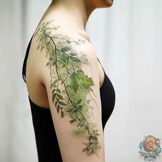 a woman's shoulder with green leaves and vines painted on the back of her arm