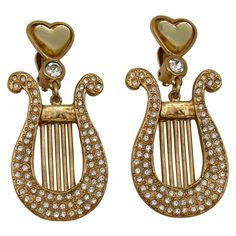 YVES SAINT LAURENT vintage gold tone dangling earrings (clip on) featuring a lyra embellished with clear crystals topped by a yellow resin heart. Embossed YSL Made in France. Indicative measurements : height approx. 6.4 cm (2.52 inches) / max. width approx. 2.7 cm (1.06 inches). Weight per earring : approx. 16 grams. Material : Gold tone metal hardware / Crystal / Resin. NOTES - This is a preloved vintage item, therefore it might have imperfections. - Colors may differ slightly from actual produ Yellow Resin, Saint Laurent Vintage, Vintage Designer Jewelry, Crystal Resin, Couture Mode, Clear Crystals, Vintage Jewels, Dangling Earrings, Vintage Designer