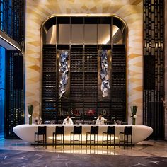 an elegant dining room with large round table and chairs in front of the bar area