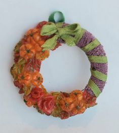 an orange and green wreath with flowers on it