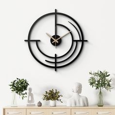 a clock that is on the side of a wall next to some vases and plants