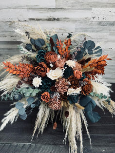 an arrangement of flowers and feathers on a wooden surface