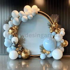 a white and gold balloon arch with balloons in the shape of a circle on a table