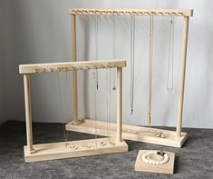 two wooden frames with necklaces hanging from them and a box on the floor next to it