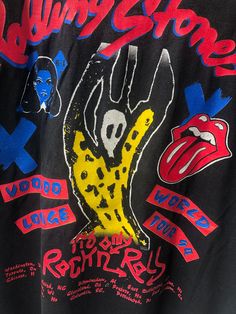 the rolling stones tour t - shirt is on display in front of a wallpapered background