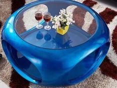 a blue table with two glasses of wine on it and a rug in the background