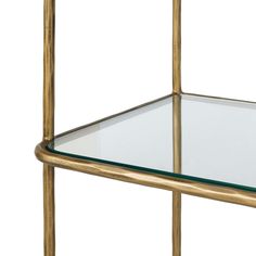 a gold metal shelf with glass shelves on each side and one shelf holding a clear glass top