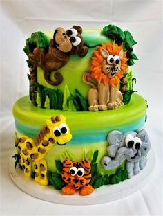 a three tiered cake decorated with jungle animals