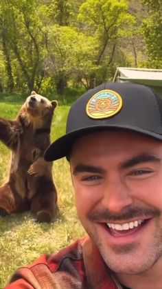 a man taking a selfie with two bears in the background