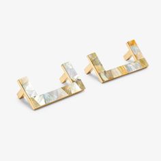 two square shaped gold earrings with mother - of - pearl inlays on each ear