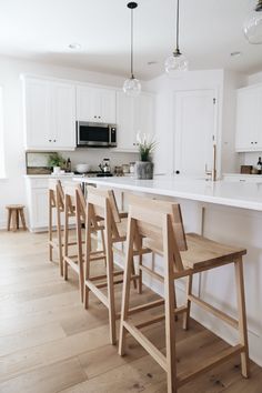 a kitchen filled with lots of counter top space and wooden chairs next to an island