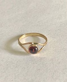 This 14 K gold ring features a 6 mm. garnet a very popular stone. The  splitter band gives to the ring a nice looking and is very comfortable. Modern Hallmarked Ruby Ring, Modern Hallmarked Round Ruby Ring, Classic Garnet Rings With Round Cut, Classic Garnet Round Cut Ring, Classic Garnet Ring With Round Cut, Classic Yellow Gold Garnet Birthstone Ring, Classic Round Garnet Ring, Classic Yellow Gold Garnet Rings, Yellow Gold Garnet Rings