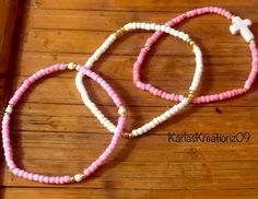 Handmade 3-piece pink, ivory and gold plated seed beaded bracelets with ivory colored cross bead (0.47 inch wide, 0.63 inch long, 0.16 inch thick). The seed beads are 3mm in various shades of pink, ivory and gold beads. Made with quality stretch cord.  Makes a great gift! Please measure your wrist before placing an order.  How to care for your bracelets:  Handle with care and please limit exposure to oils, water, fragrances, and chemicals.  See my other beautiful creations by visiting my store: Handmade Pink Beaded Bracelets For Birthday, Handmade Pink Bracelets For Birthday, Pink Tiny Beads Friendship Bracelets As Gift, Pink Tiny Beads Friendship Bracelet As Gift, Cream Stretch Bracelet As Gift, Pink Friendship Bracelets For Birthday, Pink Stackable Bracelets For Birthday, Pink Stackable Beaded Bracelets As Gift, Pink Stackable Bracelets For Birthdays