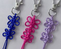 three different colored key chains with bows on them