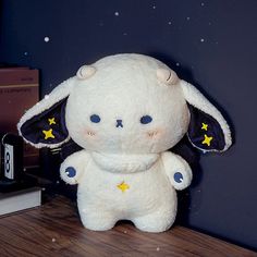 a white stuffed animal sitting on top of a wooden table