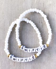 two white beaded bracelets with the word swiffie written on them