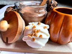 a wooden tray topped with different types of desserts next to jars and utensils