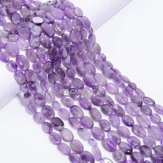 purple amethyst beads are displayed on a white surface