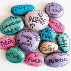 some rocks with words painted on them that say inspire, be kind to smile and be happy