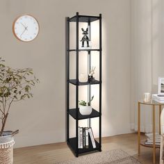 a tall black shelf with books and plants in it next to a clock on the wall