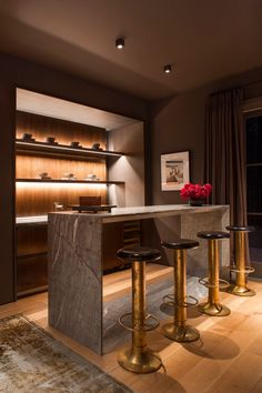 a kitchen with marble counter tops and gold stools