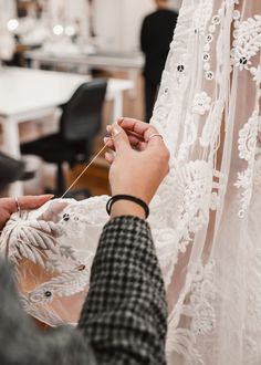 the woman is working on her wedding dress