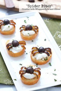 small appetizers with whipped cream and olives are on a white platter