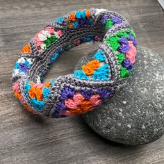 two crocheted bracelets sitting on top of a rock